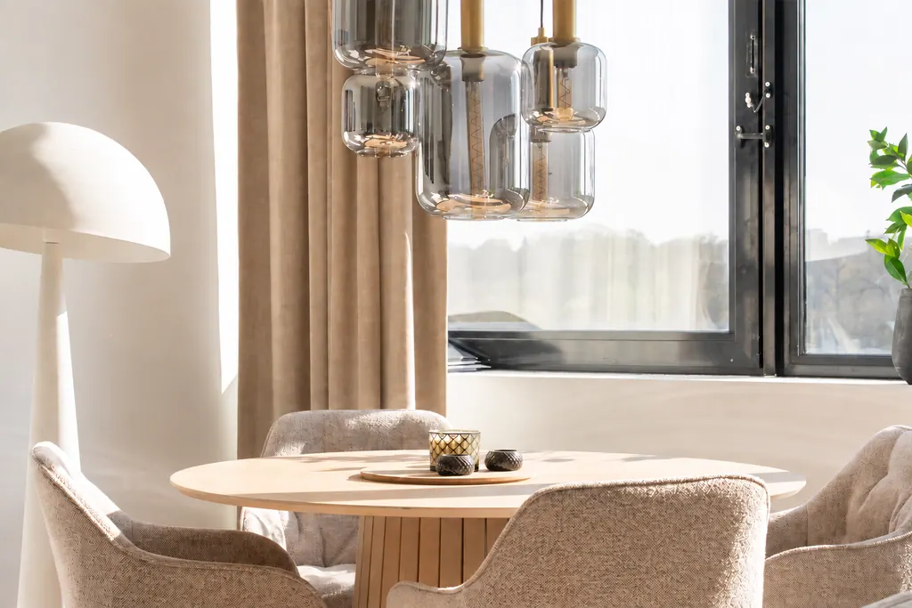Suspensions Artone en verre avec des sources lumineuses raccourcies au-dessus d’une table à manger ronde.